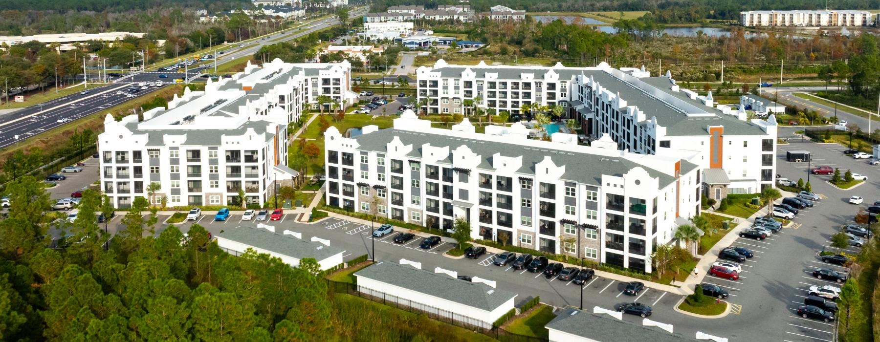 a large white building with a parking lot in front of it